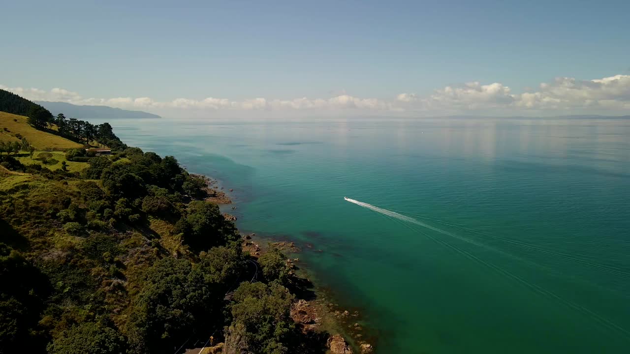 viendo pasar un barco por las montañas de nueva zelanda en la península de coromandel