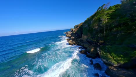 Fpv-Dynamic-flight-over-rocky-coastline-with-crashing-waves-of-Caribbean-sea-during-sunny-day---Cabo-Frances,-Dominican-Republic