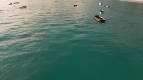 Vista-Al-Atardecer-Del-Mar-En-Calma-Con-Barcos-De-Pesca-Dispersos