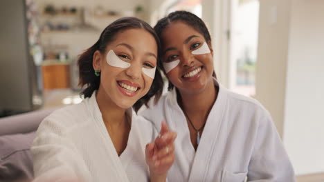 two smiling women taking a selfie with eye masks