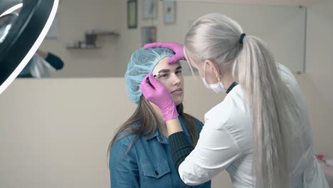 girl-undergoes-eyebrows-tattooing-with-master-slow-motion