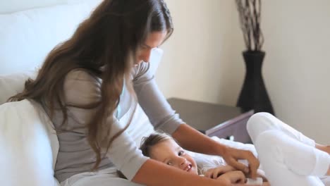 animation of flying red spots over caucasian mother playing with baby girl