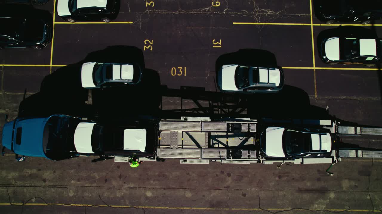 A worker ties a car to the car hauler truck for transport. Top view .