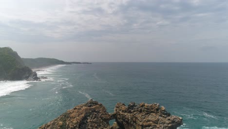 Aerial-jib-down-shot-of-the-rock-formation-La-Ventanilla,-Oaxaca