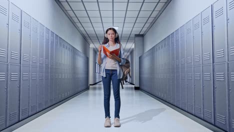cuerpo lleno de estudiante adolescente asiática con una mochila leyendo un libro y pensando y mirando a su alrededor luego levantando su dedo índice mientras estaba de pie en el pasillo