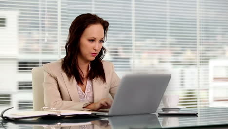 smiling businesswoman using her laptop