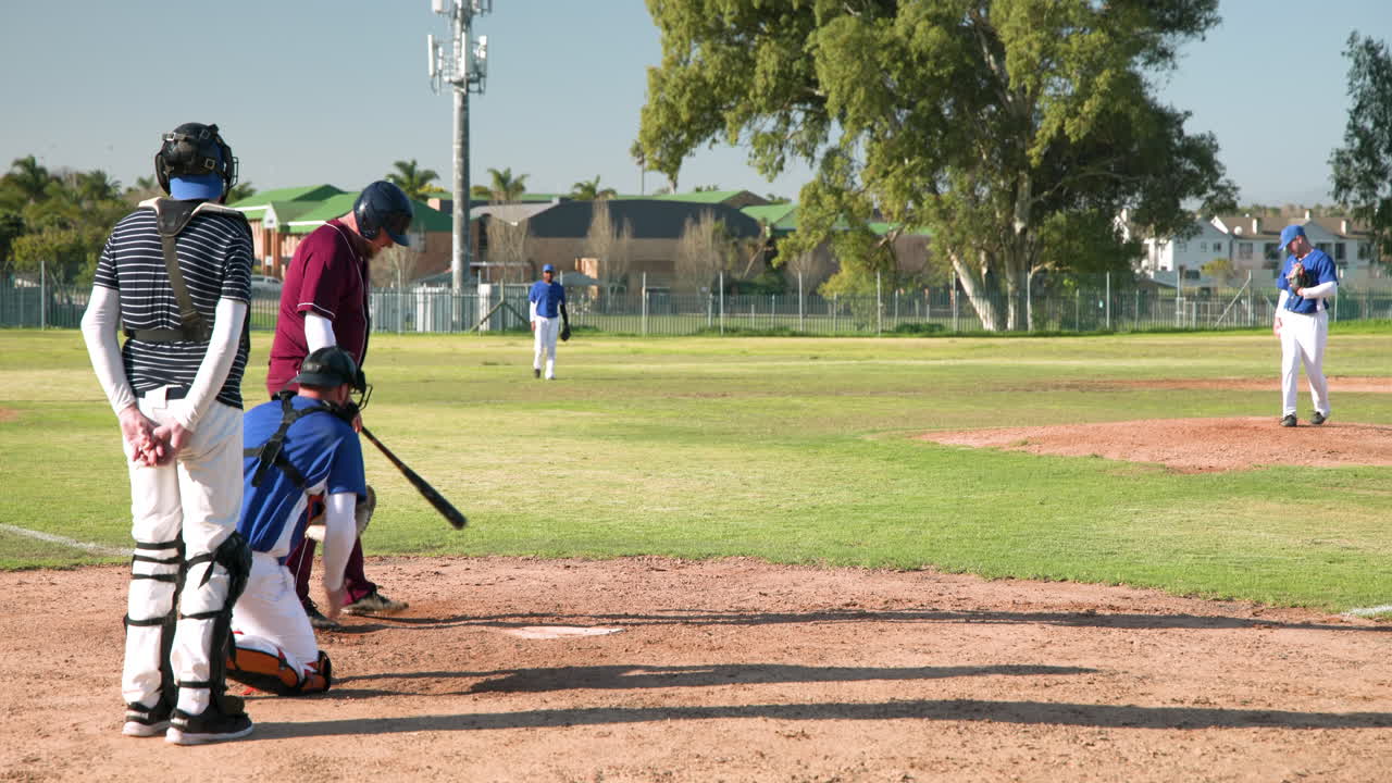 Partita di baseball, battitore pronto a colpire mentre ricevitore e arbitro osservano attentamente.