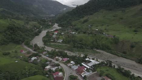 Aerial-tilt-from-Prusia-village-to-cloudy-jungle-valley,-central-Peru