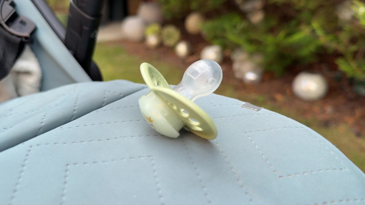 Baby Pacifier Resting on a Pram or Pushchair Outdoors Close Up