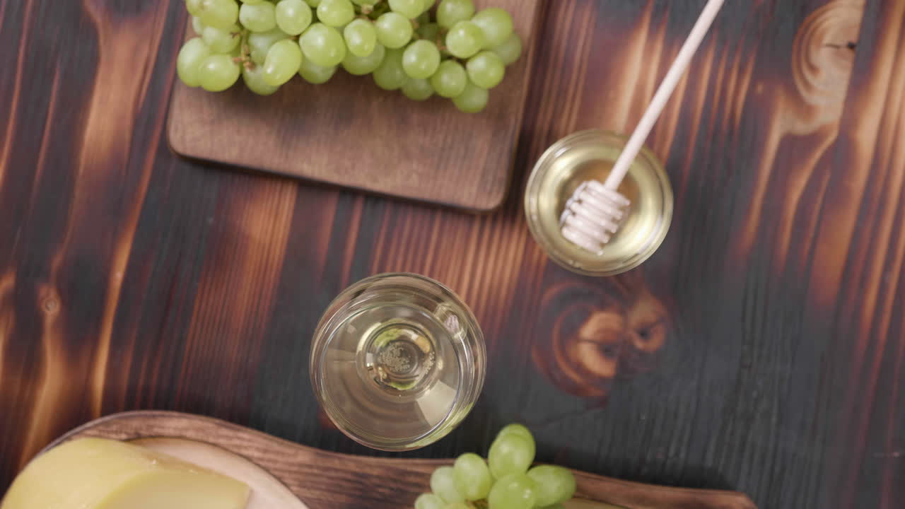 Cheese, grapes, honey, and wine still life