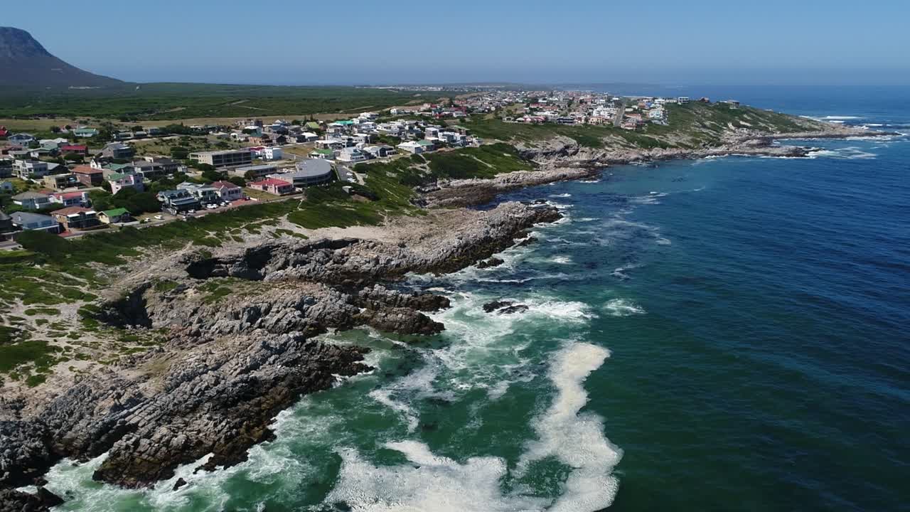 Ripresa aerea che scende verso una costa oceanica frastagliata a De Kelders, Sudafrica
