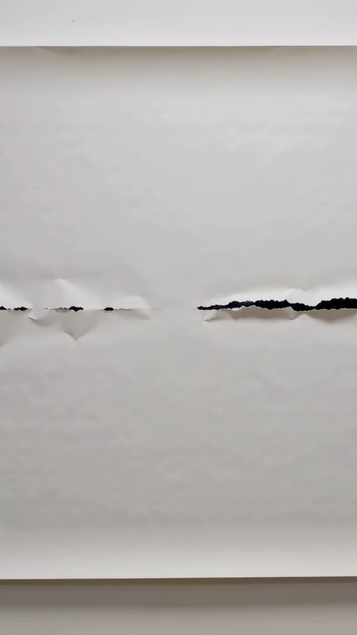 Vertical video: Paper tear center, camera shifting lifting edges, revealing gap and showing texture