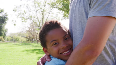 Slow-Motion-Portrait-Shot-Of-Father-Hugging-Son-In-Park