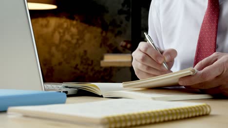 primer plano de las manos de un empleado tomando notas en un cuaderno. trabajando con datos y análisis.