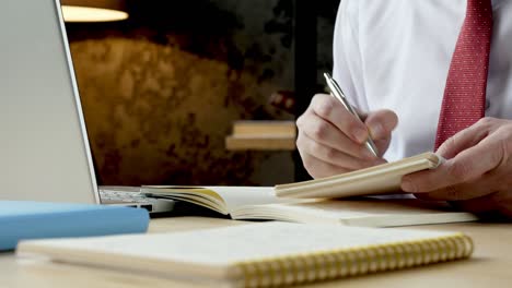 close-up of an employee  hands taking notes in a notebook. working with data and analysis.