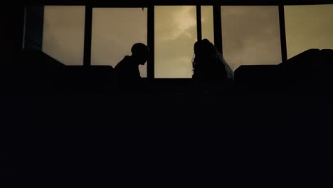 newlyweds-are-sitting-in-a-cafe-at-a-table-at-sunset-silhouette