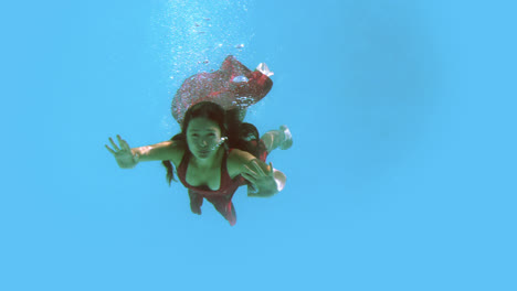 morena en vestido de noche nadando en la piscina