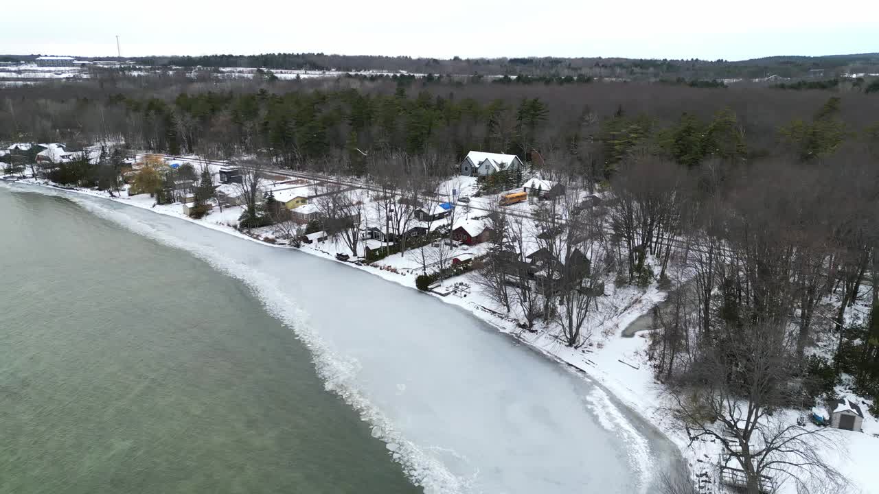 drone dando vueltas sobre las casas de la orilla del lago en un día de invierno en ontario