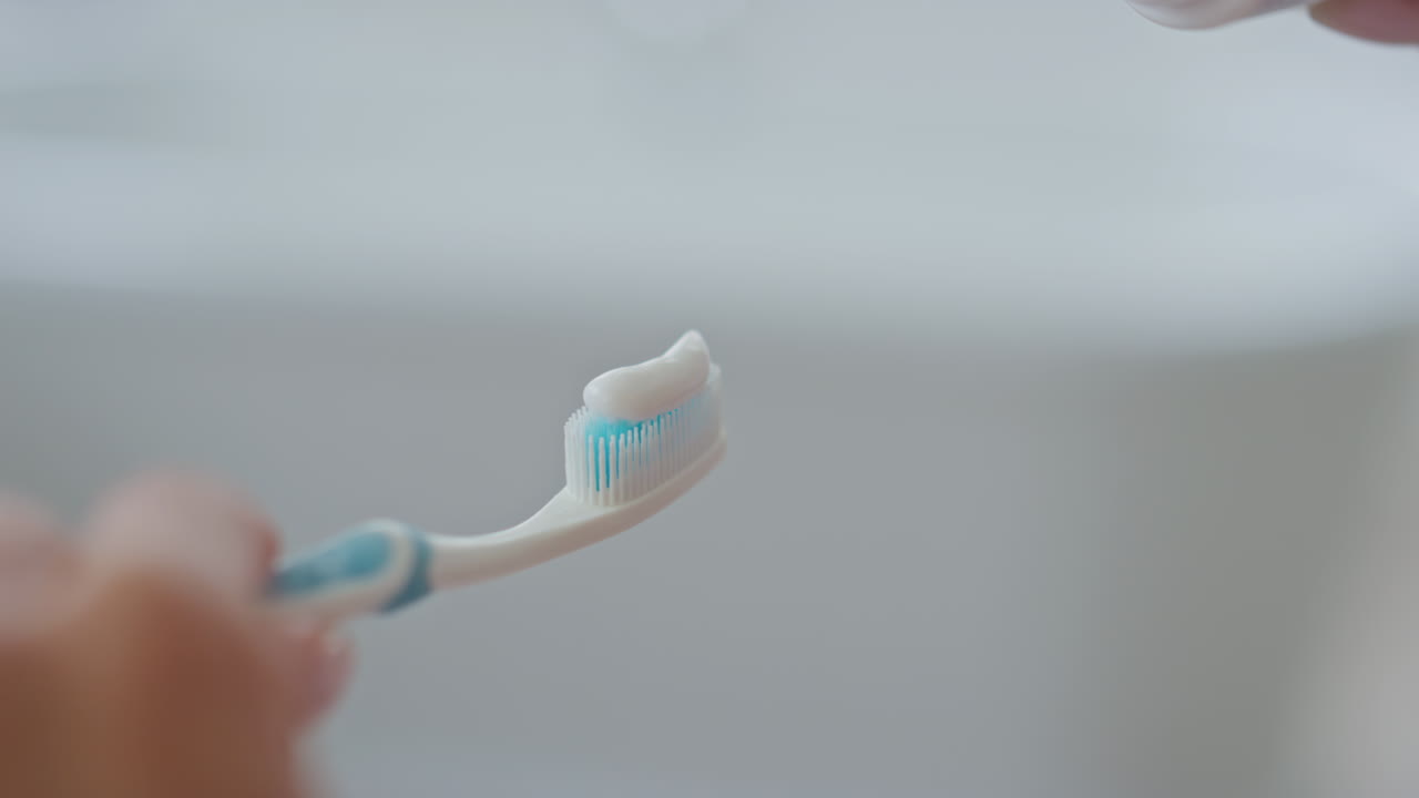 Lady hand applying toothpaste brush indoors closeup. Dental hygiene healthcare