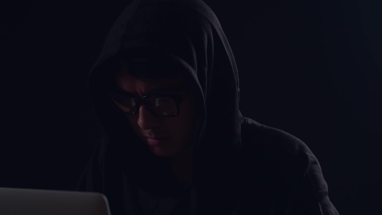 Hacker asiatico uomo che hackera con un laptop