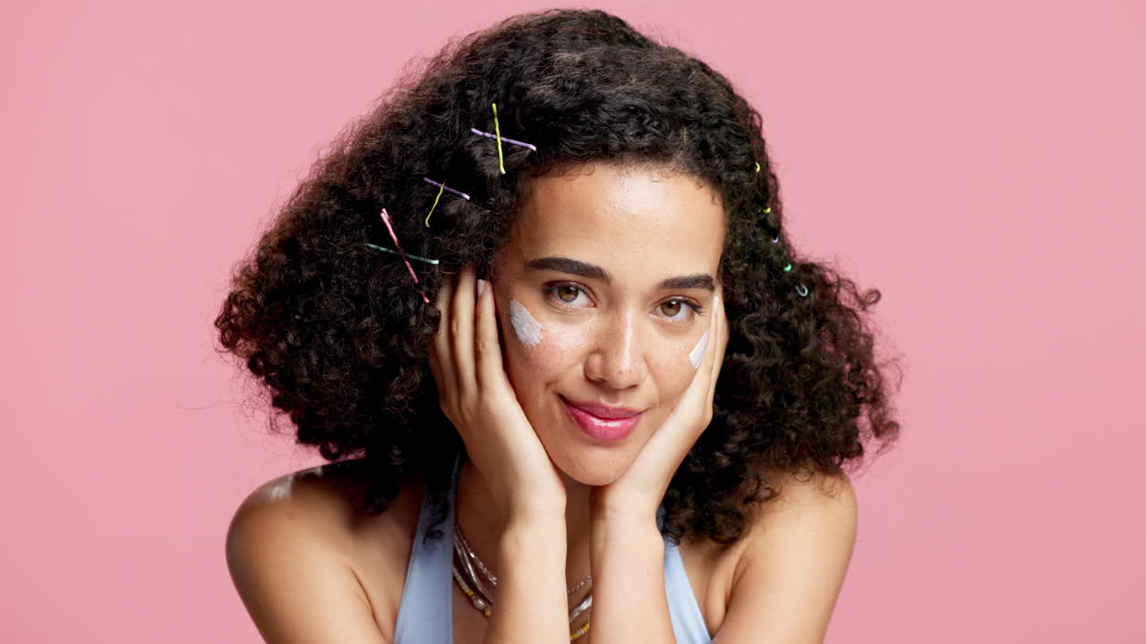 Donna con capelli ricci e crema sul viso