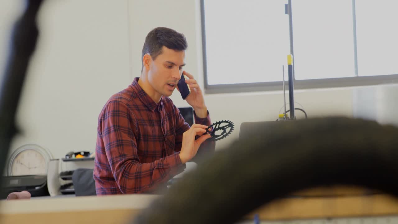 mecánico sosteniendo el anillo de la cadena mientras habla por teléfono móvil 4k