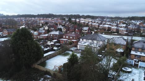 snowy aerial village residential neighbourhood winter frozen north west houses and roads descend low