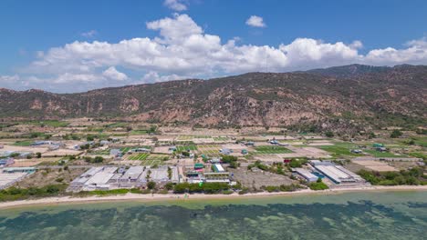 Aerial-view-of-kitesurfing-resort-on-blue-lagoon-with-moving-clouds