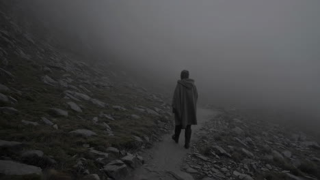 person hiking in foggy mountains