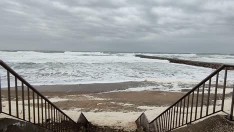 storm weather, breaking waves and seafoam at the beach shore, tracking in