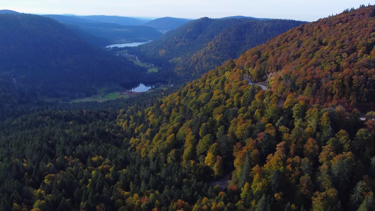 vista aérea del hermoso bosque de follaje naranja y lagos lejanos durante la temporada de otoño en la montaña francesa vosges
