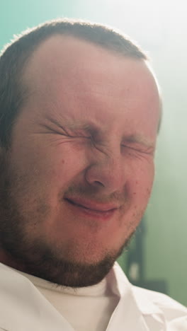a close-up view of a technician smiling while examining samples through a microscope in a laboratory