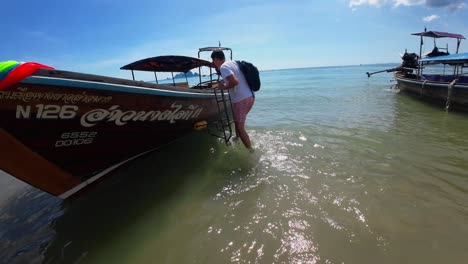 Man-going-on-board-a-long-tail-boat-in-Krabi,-Ao-Nang,-Railay-beach-in-Thailand