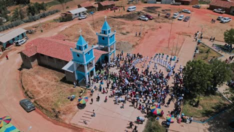 Aerial-shot-of-a-wedding-in-a-small-community-of-Ancash,-people-outside-congratulate-the-new-couple