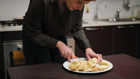 in a home kitchen a woman cuts cantucci biscuits before second baking