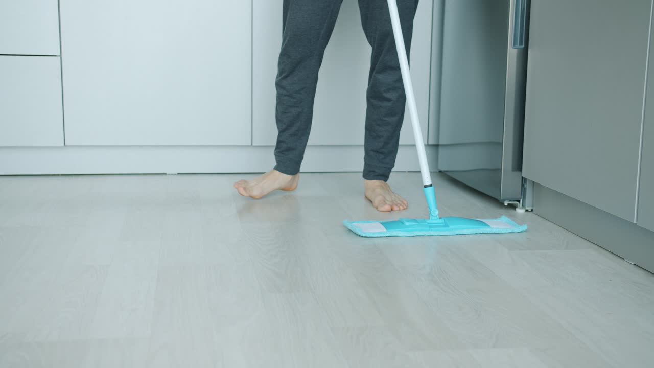 Person Mopping a Kitchen Floor