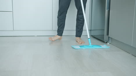 person mopping a kitchen floor
