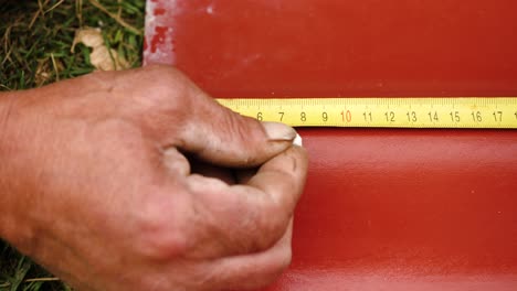 measuring roofing material with tape measure