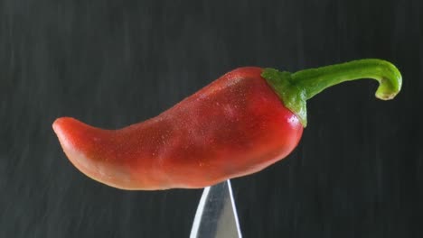 Spicy-Food:-Water-Spraying-on-Burning-Red-Chili-Pepper-Stuck-on-a-Knife