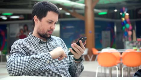 hombre usando un teléfono inteligente en un café
