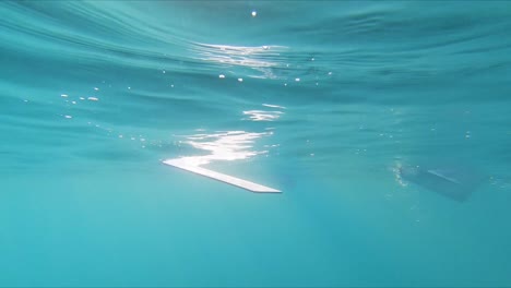 underwater lurking point of view watching rowing oars paddling through water