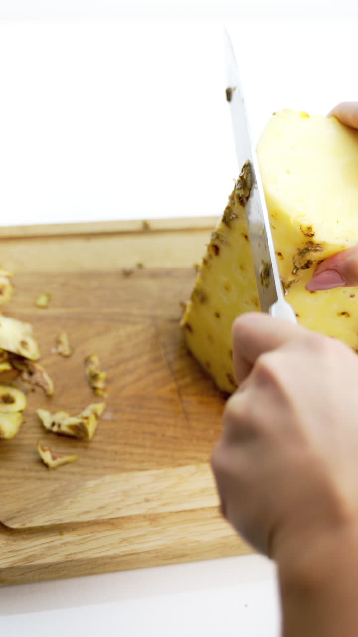 Hands slicing pineapple. Hands of woman peeling pineapple with knife