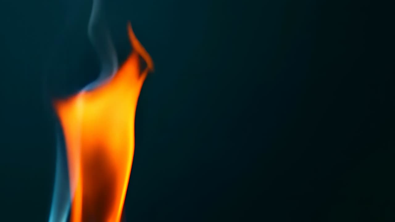 Flame and smoke rise in dark background. Flame and smoke move together in the dark background creating a simple scene of fire