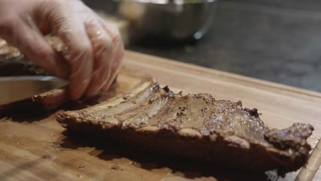 Cutting-beef-ribs-on-wooden-cut-board-at-meat-tasting-event