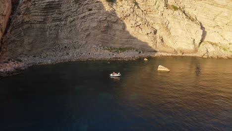 Drone-shot-pulling-away-from-a-boat-sitting-along-the-very-steep-coast-of-Spain