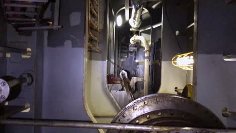 pov of technician pointing flashlight in a dark engine room of a ship