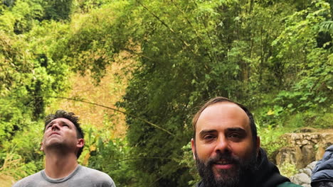 two male tourists are happy and screaming when they arrive at gò lào waterfall, mai châu, vietnam