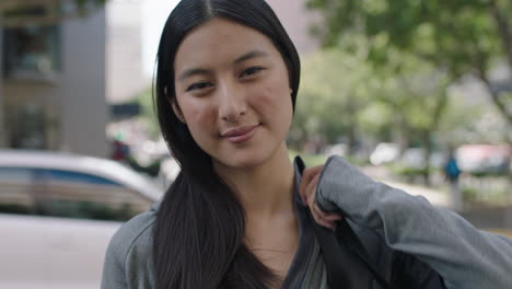 portrait of lovely young beautiful asian woman looking smiling cheerful on urban city sidewalk