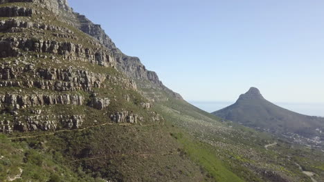 4K-high-quality-aerial-sunny-blue-sky-footage-of-spectacular-scenic-Lion's-Head-Mountain,-rocky-hills-with-hiking-trails,-Atlantic-Ocean-coast-panorama-in-Western-Cape,-Cape-Town,-South-Africa