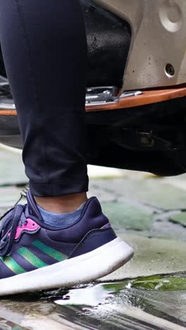 persona que despliega un soporte de motocicleta con el tiempo